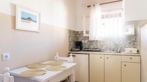 A compact kitchen with a white countertop, a coffee machine, and a tiled backsplash. - BOHOTEL Eleonas Anex Apartments (Corfu)