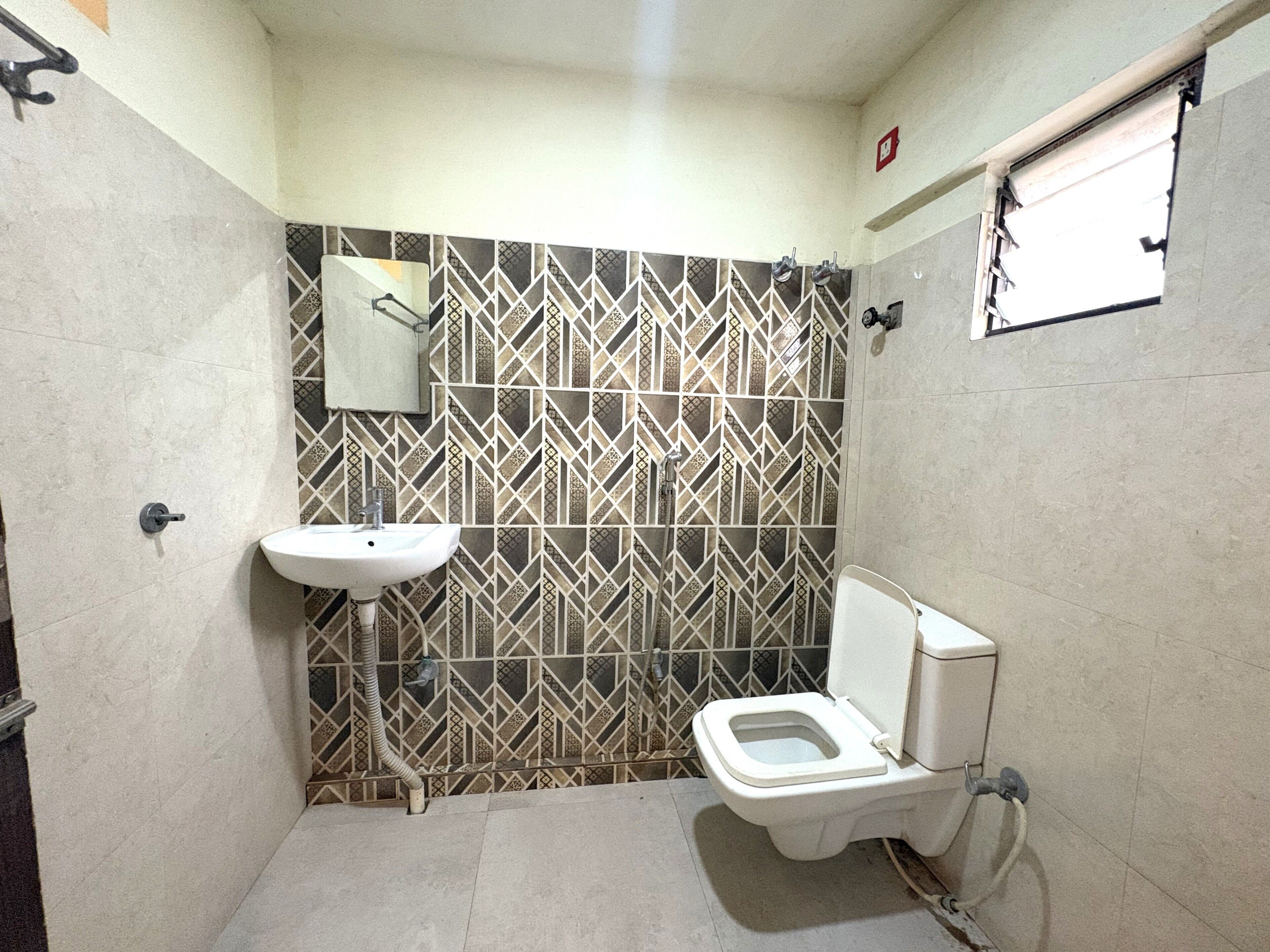 Ein kleines Badezimmer mit Toilette, Waschbecken und Spiegel.