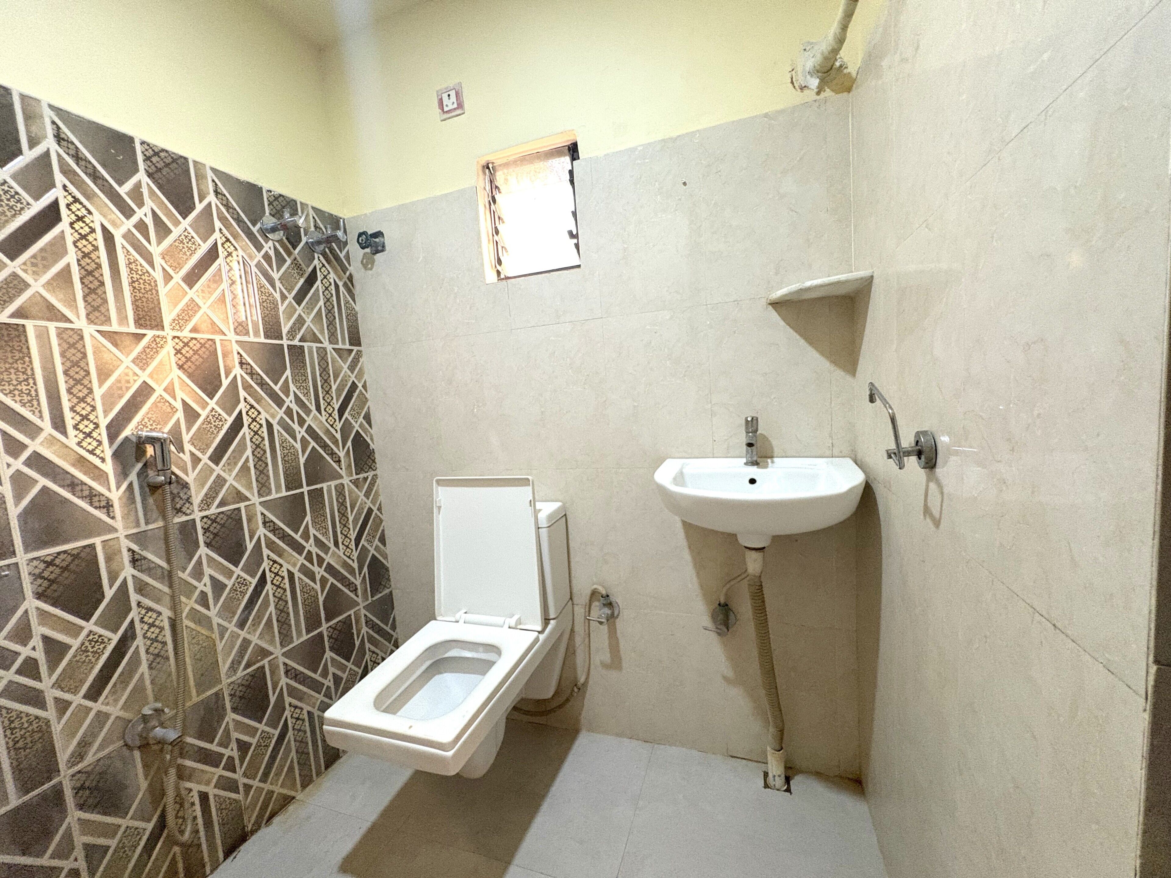 A small bathroom with a toilet, a sink, and a shower.