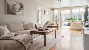 En moderne stue med sofa, sofabord og et billede på væggen.