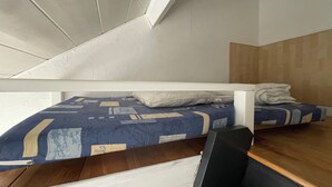 Una habitación con literas, un escritorio y una silla.