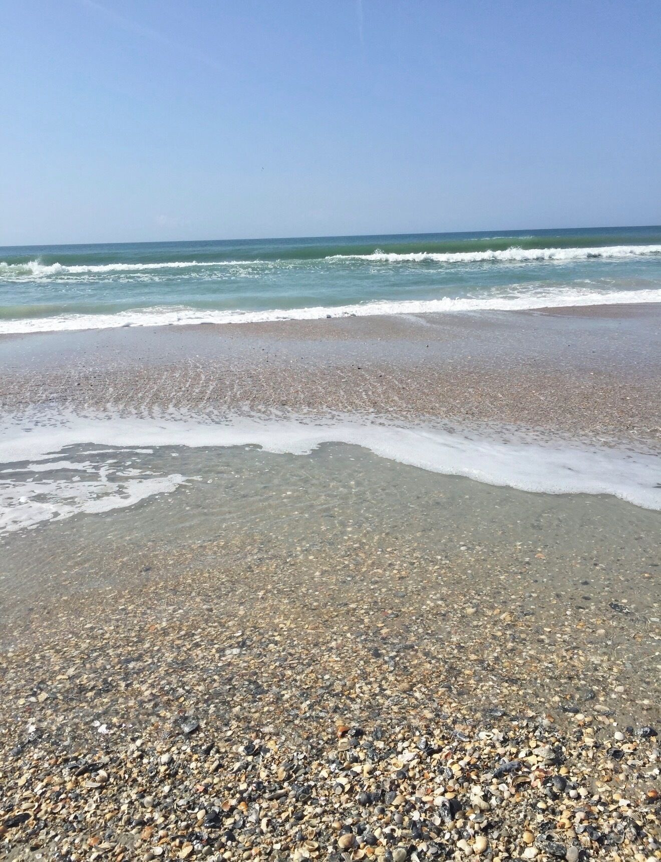 A beach with pebbles and waves.
