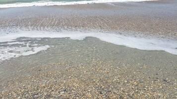 A beach with pebbles and waves.