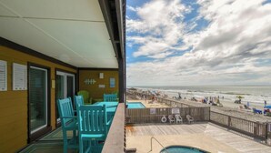 Een balkon met een zwembad, stoelen en uitzicht op het strand.