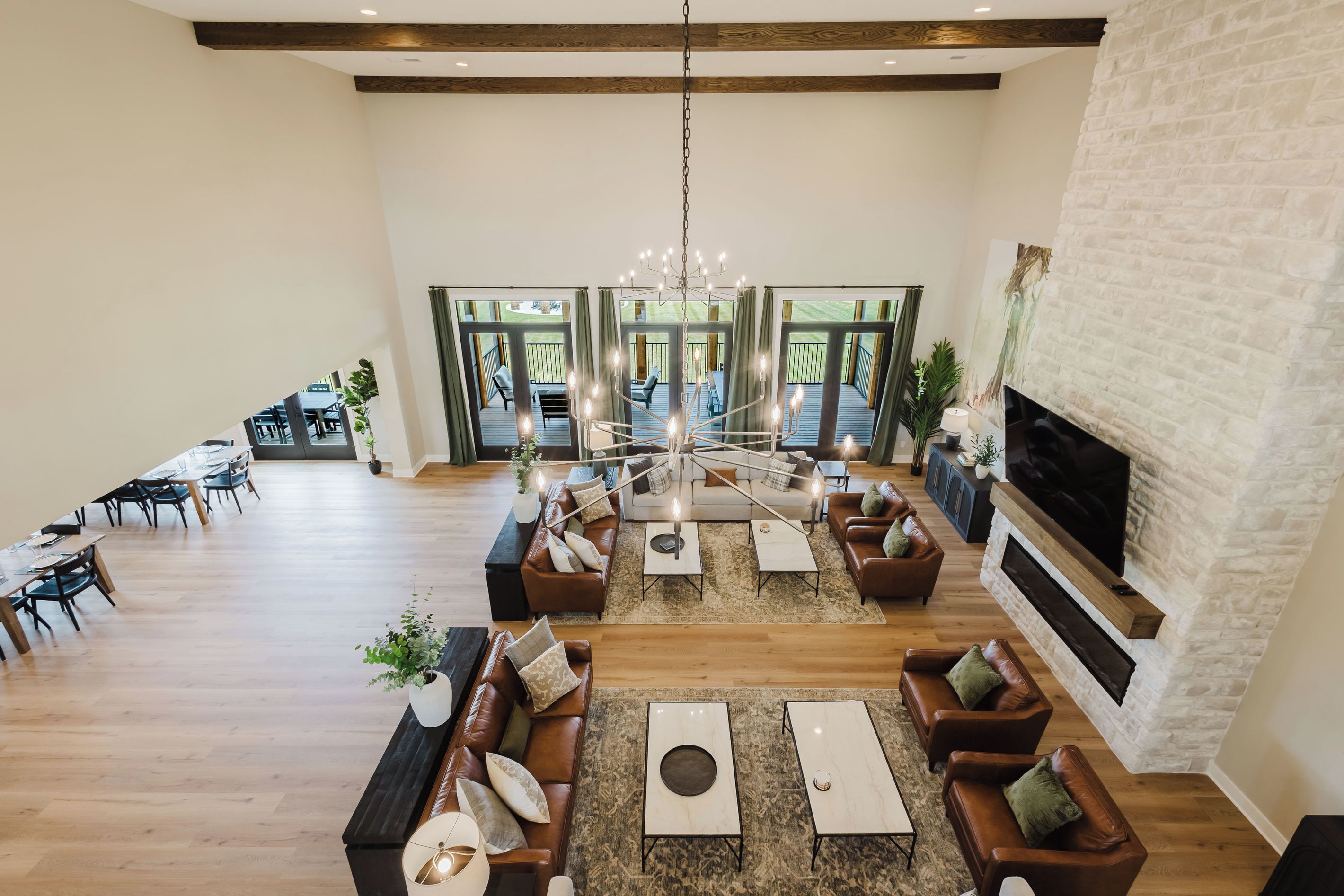A spacious living area with a fireplace, seating arrangements, and a view of the outdoor deck.