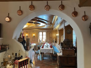 A restaurant with a wooden interior, a table set for dining, and a wine rack with bottles.