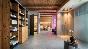 Un cuarto de spa con estantes de madera, una camilla de masaje y una zona de ducha.