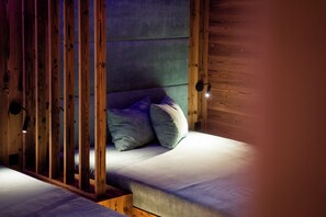 A room with a bed, wooden beams, and a green wall.