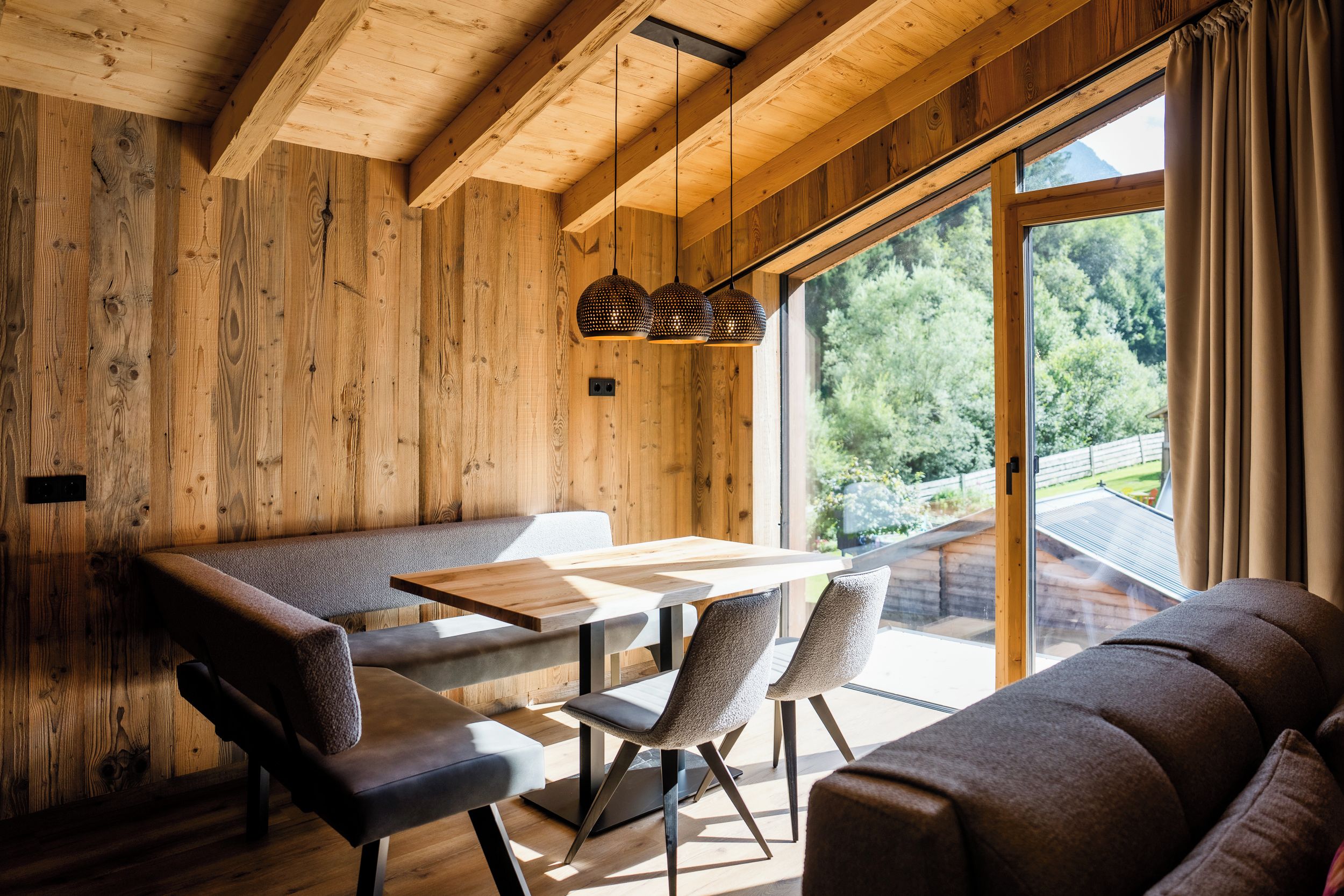 Un interior de madera con una mesa de comedor, sillas y un sofá.
