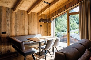 A wooden interior with a dining table, chairs, and a sofa. - Slow Fine Chalets (Neustift Im Stubaital)