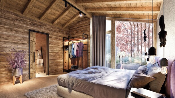 Un dormitorio con techo de madera, cama con manta mullida, mesita de noche con lámpara y ventana con vista a árboles.