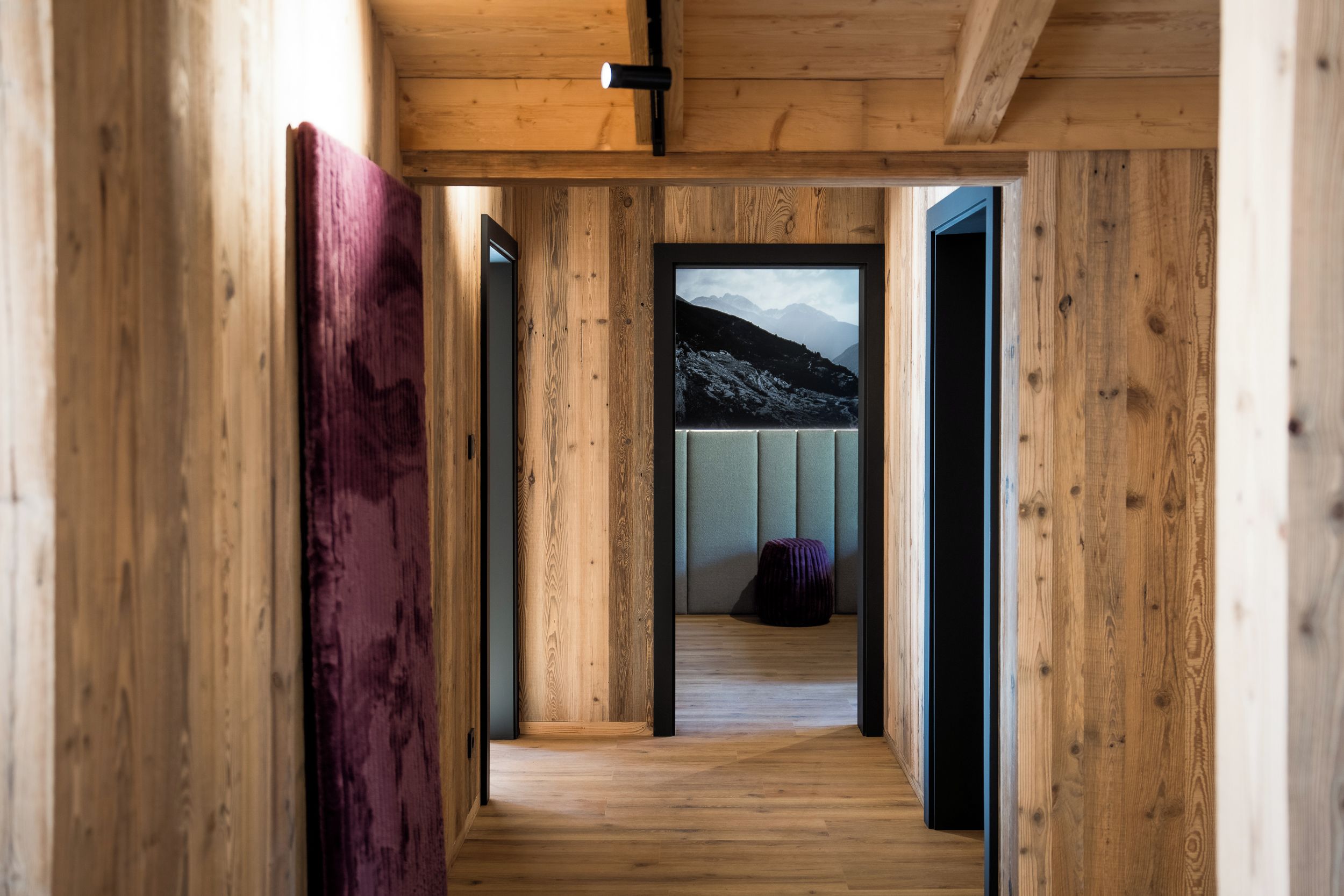 Un pasillo de madera con vista a un paisaje montañoso a través de un vidrio.