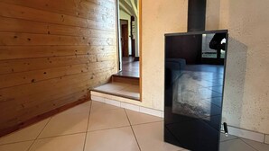 Una habitación con paredes de madera, suelo de baldosas y un mueble negro.