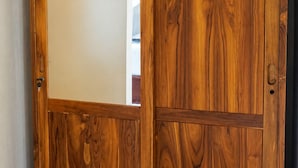 A wooden wardrobe with a mirrored door and a sliding door. - Fortuna Romantic Villa Petulu by TVM (Ubud)