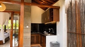 A modern kitchen with dark cabinetry, a black countertop, and a sink. - Fortuna Romantic Villa Petulu by TVM (Ubud)