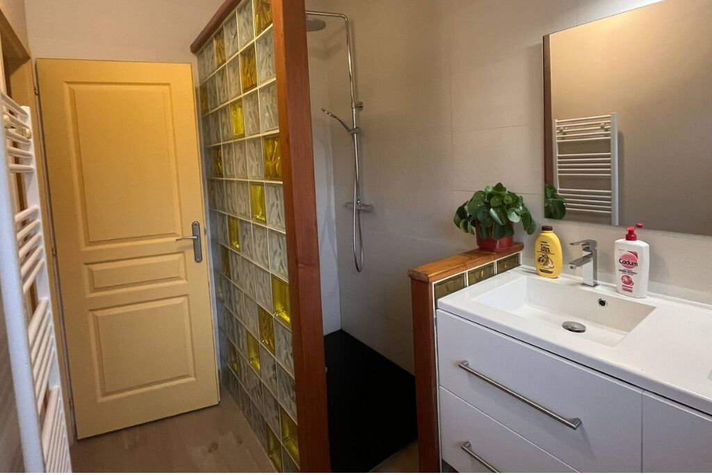 A bathroom with a shower, a sink, and a mirror.