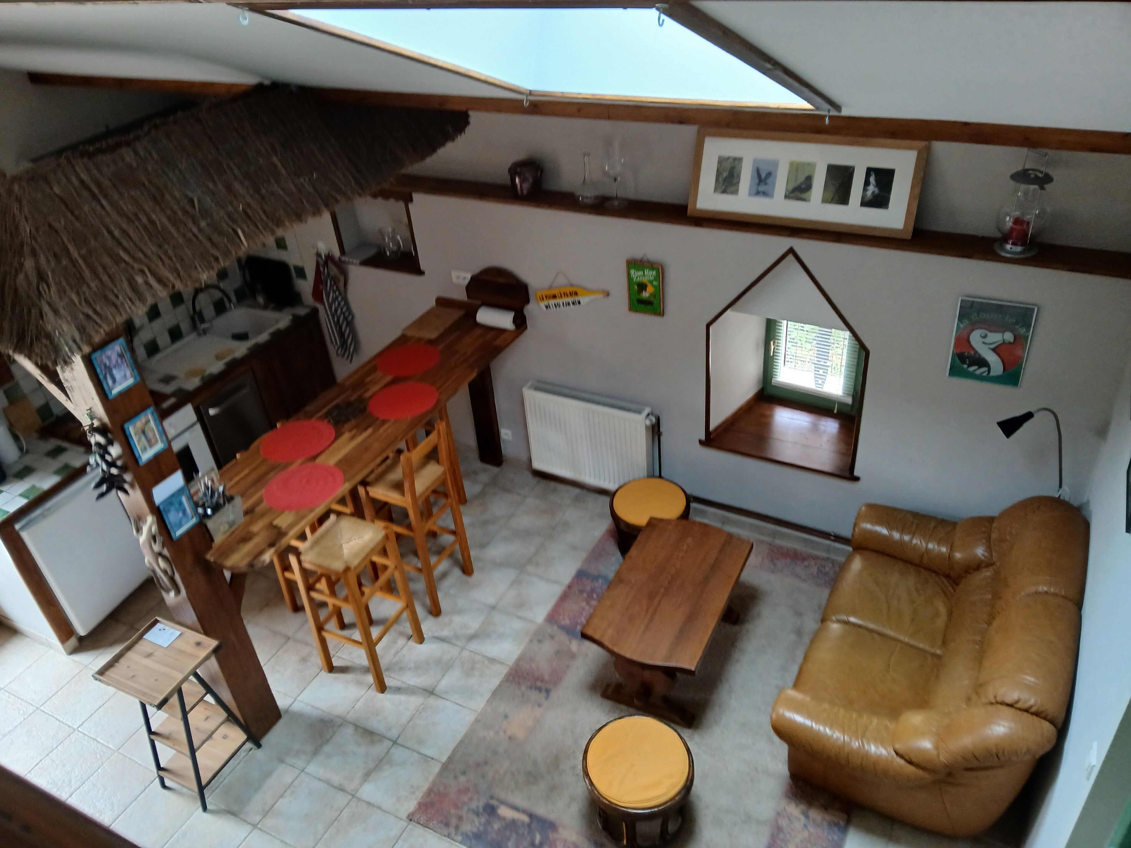 A compact living space with a dining area, a sofa, a small table, and a window with a view.