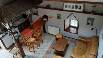 A compact living space with a dining area, a sofa, a small table, and a window with a view.