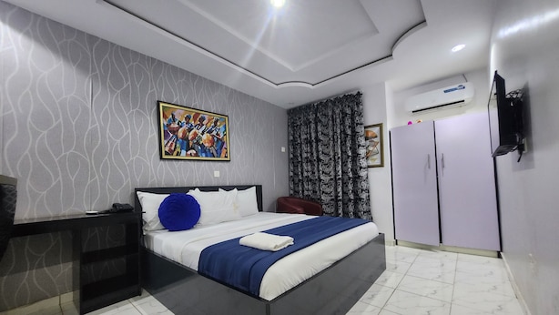 Une chambre moderne équipée d’un lit, d’un bureau, d’une armoire et d’un appareil de climatisation.