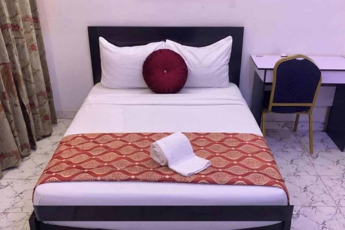 Ein Hotelzimmer mit einem Bett, einem Schreibtisch und einem Stuhl.