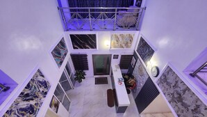Un vaste atrium doté d’un haut plafond, d’un espace de détente central et d’œuvres d’art exposées sur les murs.