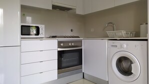 Una cucina moderna con forno a microonde, forno e lavatrice.