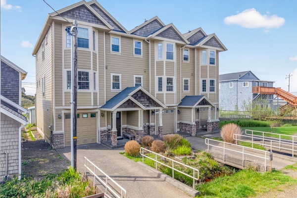 Modern coastal property with stone accents and thoughtful landscaping in a charming beachside neighborhood.