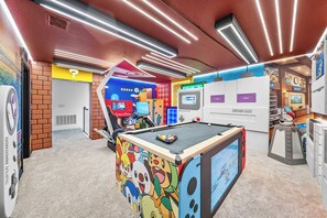 Ein helles Zimmer mit Billardtisch, einer Nintendo Switch Konsole und einer Super Nintendo Spielestation.