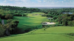 Ein Golfplatz mit mehreren Bunkeranlagen und einer angrenzenden Straße.