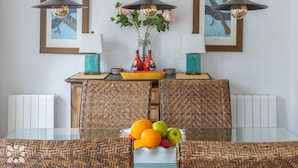 A dining area with a glass table, woven chairs, and pendant lights. - Villa CATALINA by Abahana Villas (Teulada)
