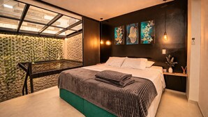 Un dormitorio moderno con una cama, una mesita, un estante en la pared y un tragaluz.