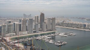 A high-rise urban area with a marina and docked boats. - Prime 2BR in Damac Heights Marina (Dubai)