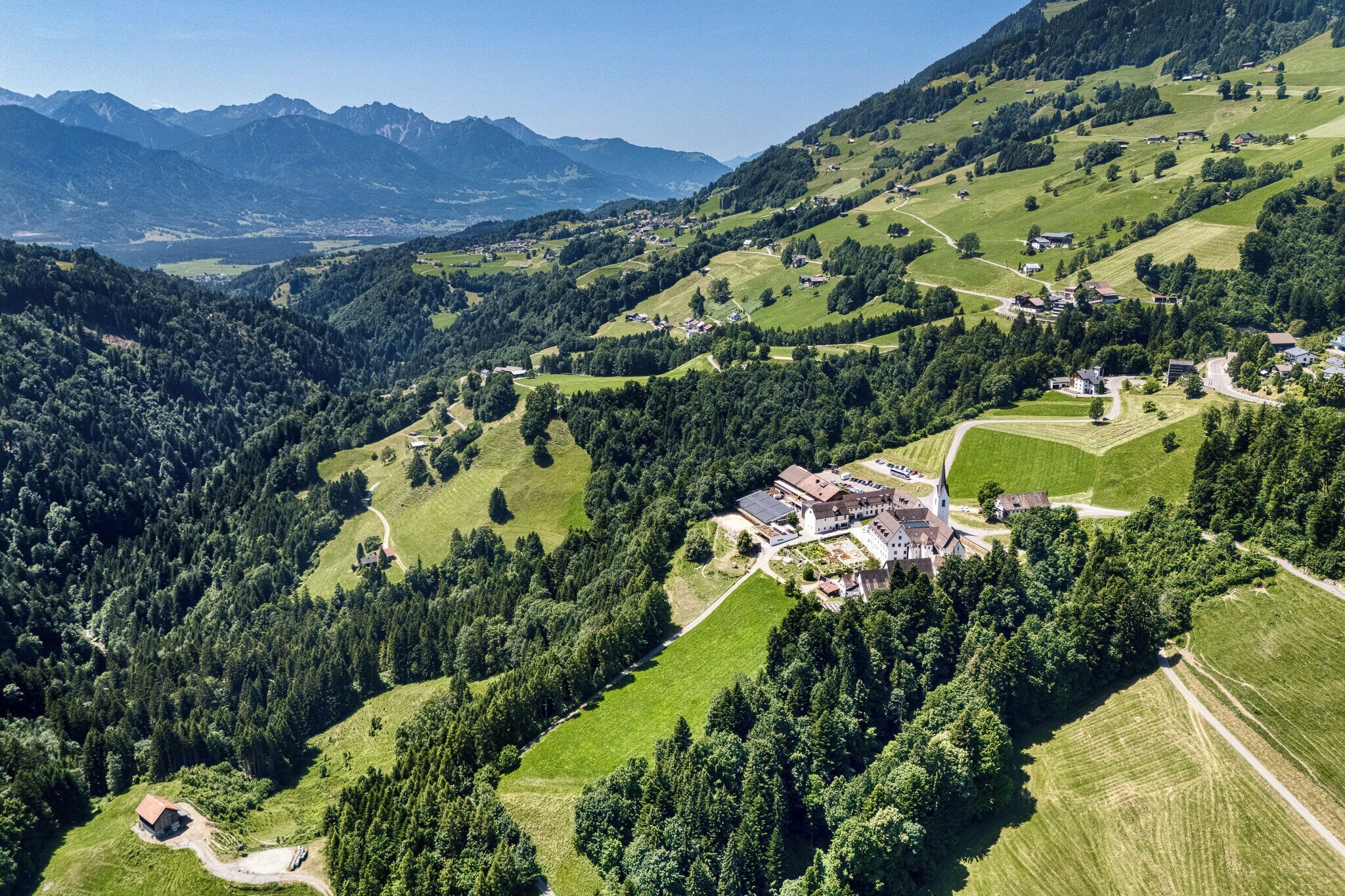 Un paysage montagneux avec un petit village, des maisons et une église.