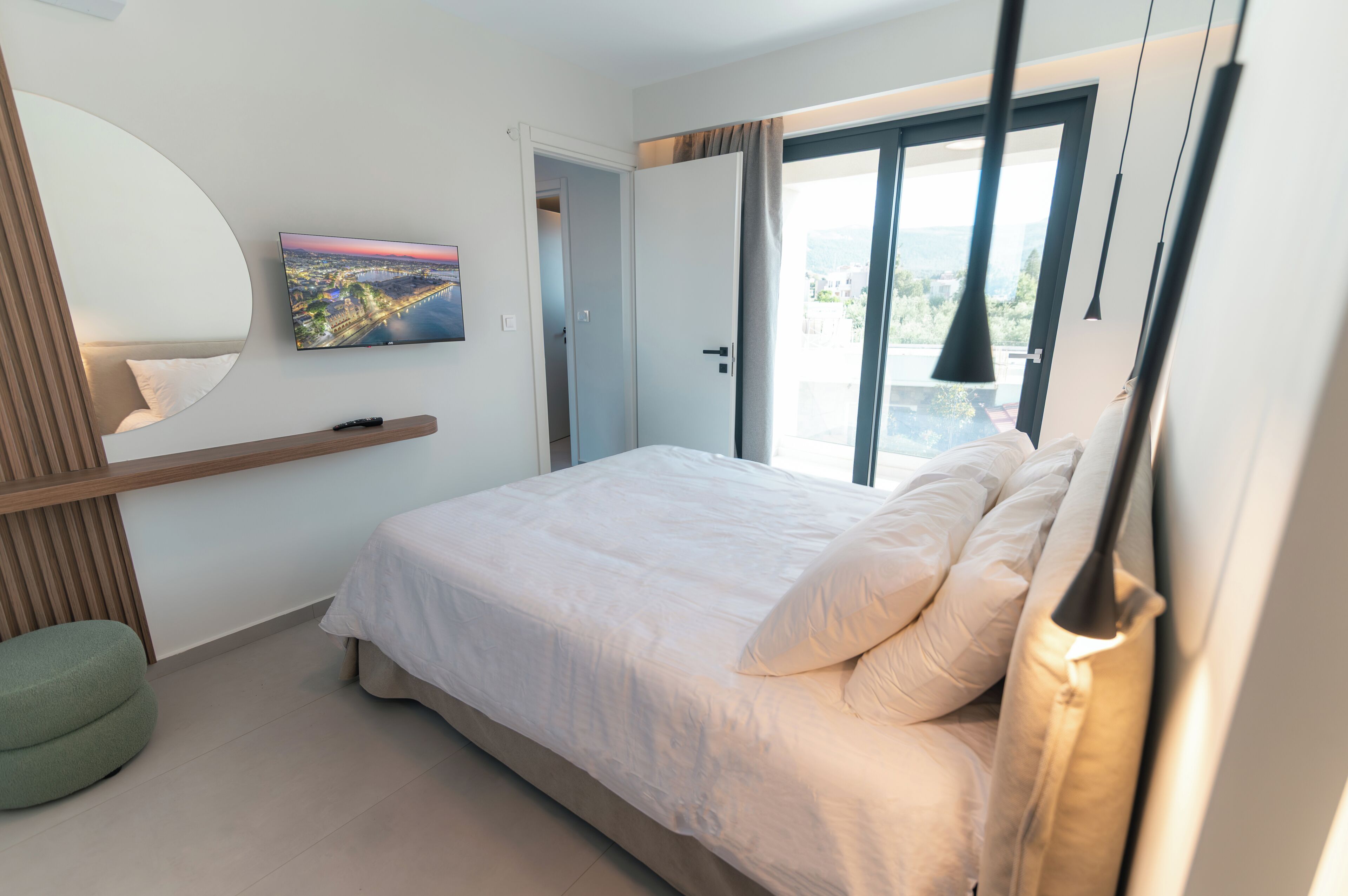 Ein Schlafzimmer mit einem Bett, einem Fernseher, einem Fenster und einer Tür.