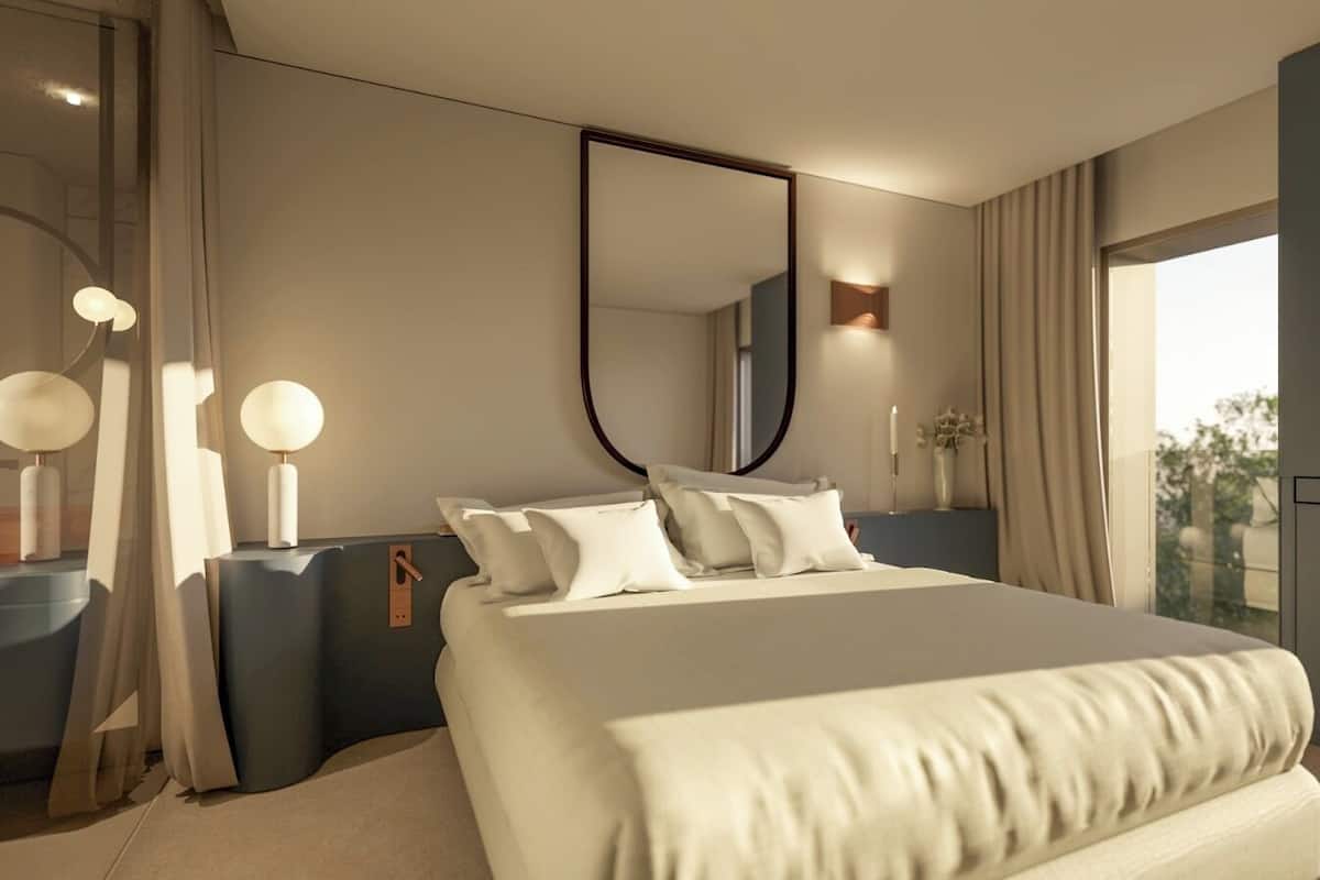 Ein modernes Schlafzimmer mit einem großen Bett, Nachttischen, einem Spiegel, einem Beistelltisch und einem Fenster mit Vorhängen.