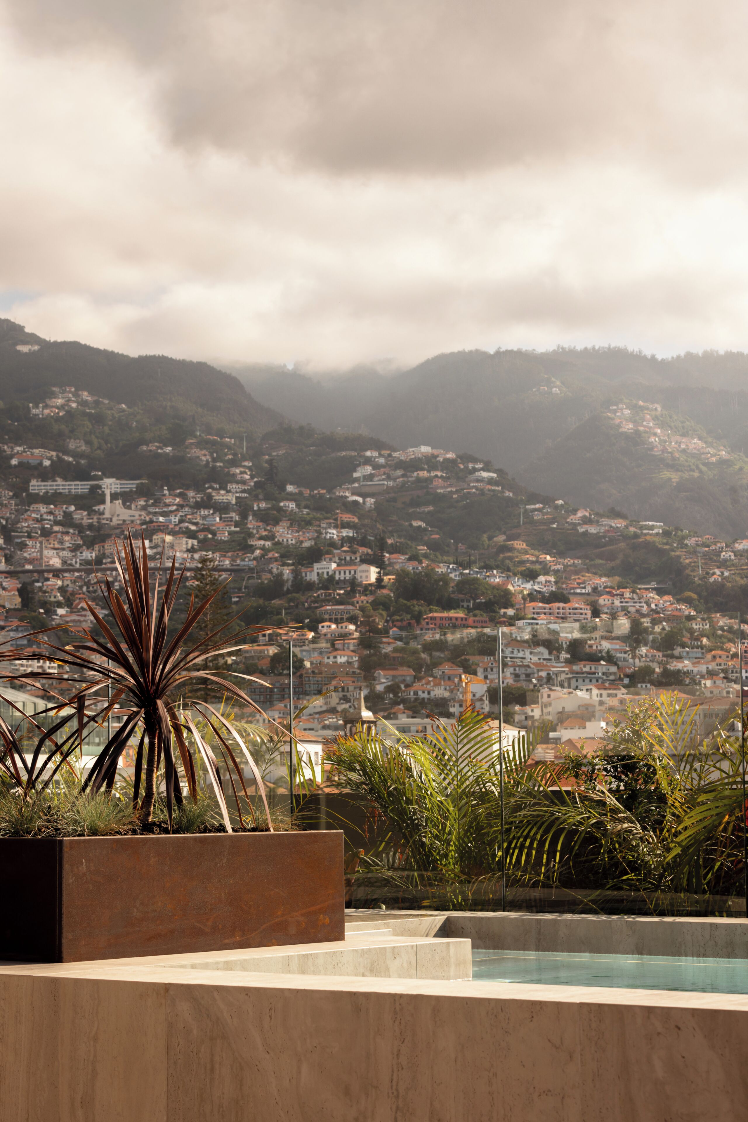 A pool area with a view of a hillside town.