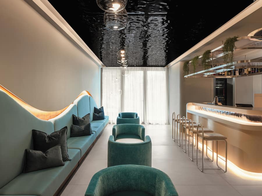 Een modern interieur met een bank, stoelen en een bar.