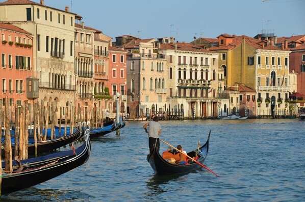 A canal with gondolas, historic buildings, and a person in a gondola. - Bright Top-Floor Retreat with Panoramic Terrace in the Heart of Venice (Venice)