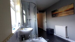 A modern bathroom with a large bathtub, a sink, and a glass shower enclosure. - Room-peaceful Village Retreat (Morpeth)