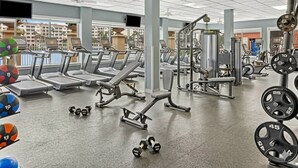 Een sportschool met loopbanden, krachtapparaten en losse gewichten.