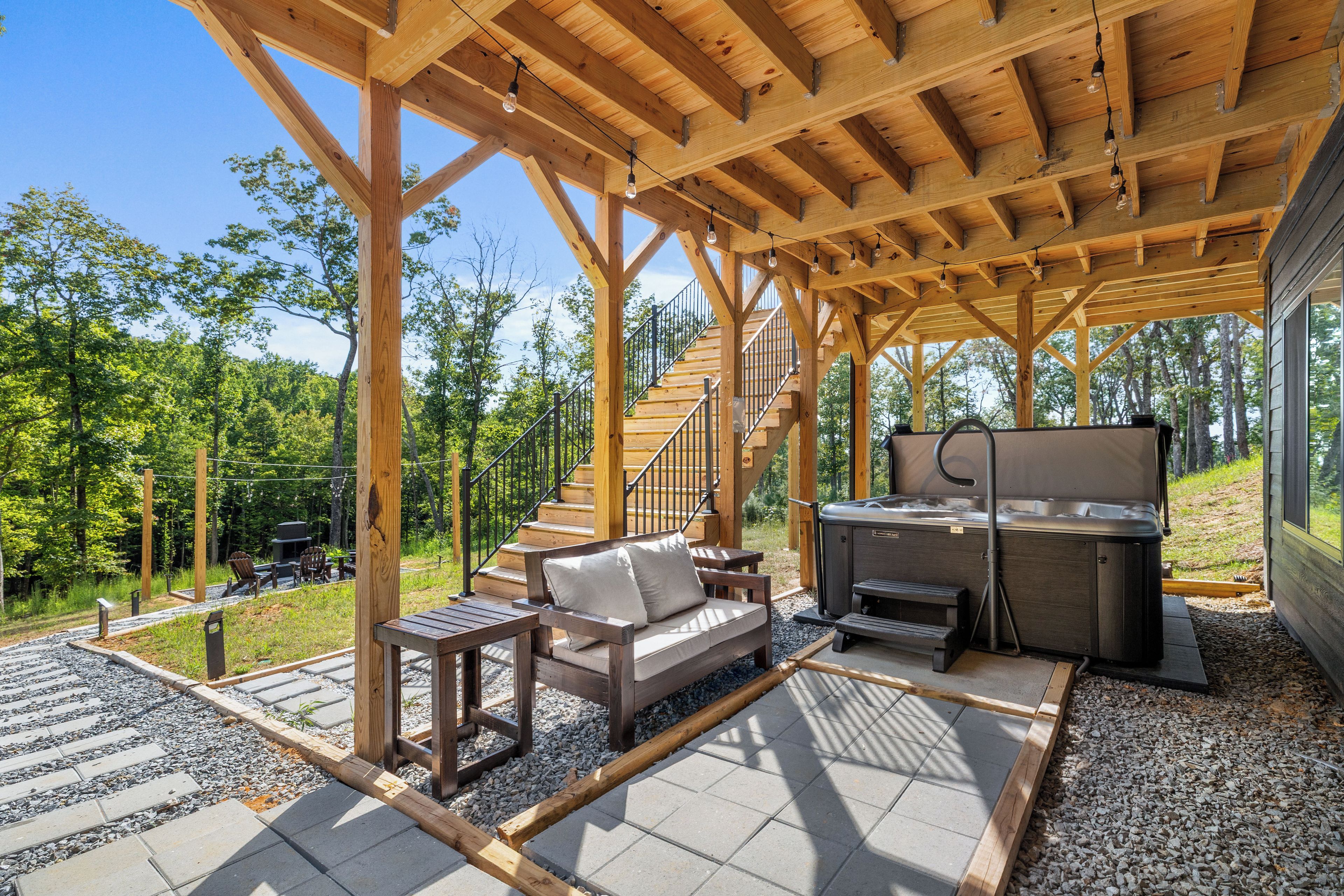 A covered outdoor area with a wooden deck, a barbecue grill, and a seating area with a sofa and chairs.