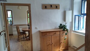 Un tavolo da pranzo in legno con sedie, un armadietto in legno, uno specchio e una finestra con vista.
