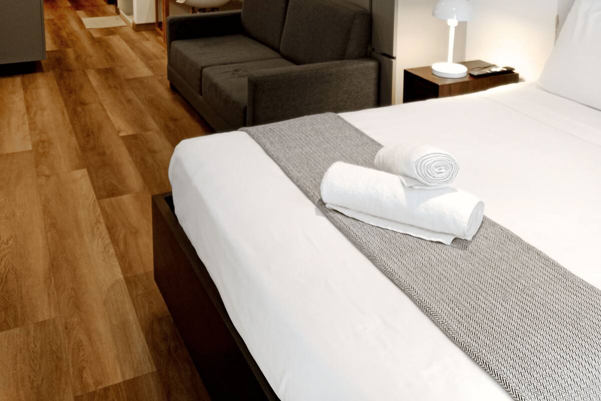 Una habitación de hotel con cama, sofá, escritorio y silla.