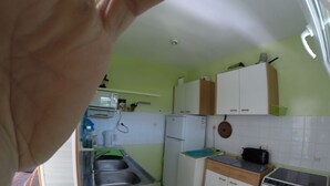 A compact kitchen with a sink, a refrigerator, a stove, and cabinets. - Sea, Relaxation and Pink Granite / 3-person apartment 300m from the beach (Trébeurden)