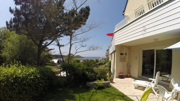 A house with a balcony, a lawn, and a view of the sea. - Sea, Relaxation and Pink Granite / 3-person apartment 300m from the beach (Trébeurden)