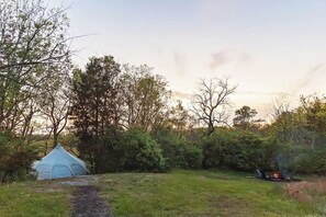 A tent in a grassy area with trees and a fire pit. - ★Escape & Relax ~ Breathtaking Creekside Getaway with Outdoor Tub★ (Georgetown)