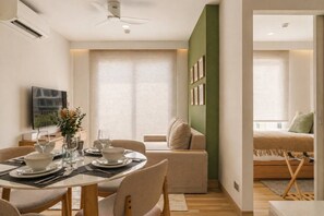 Ein modernes Wohnzimmer mit Essbereich, einer Couch, einem Fernseher und einem Bett mit Blick.