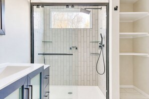 Een douche, handdoeken, zeep, toiletpapier
