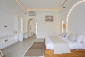 Ein modernes Schlafzimmer mit einem großen Bett, einem Holz-Kopfende, einem Nachttisch, einem Teppich und einer Wandleuchte.