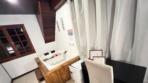 A room with a wooden vanity, a small refrigerator, a chair, a desk, and a window with curtains. - villaggio farnese (Campos do Jordão)
